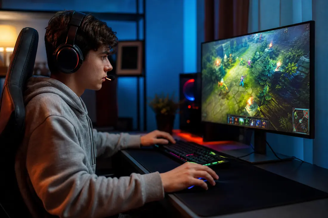 Joueur en train de jouer en ligne sur PC avec un casque, écran affichant un jeu multijoueur en réseau